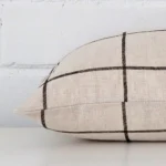 A cushion arranged sideways in front of a wall. The rectangle size and linen fabric are shown and the seams are clearly visible.