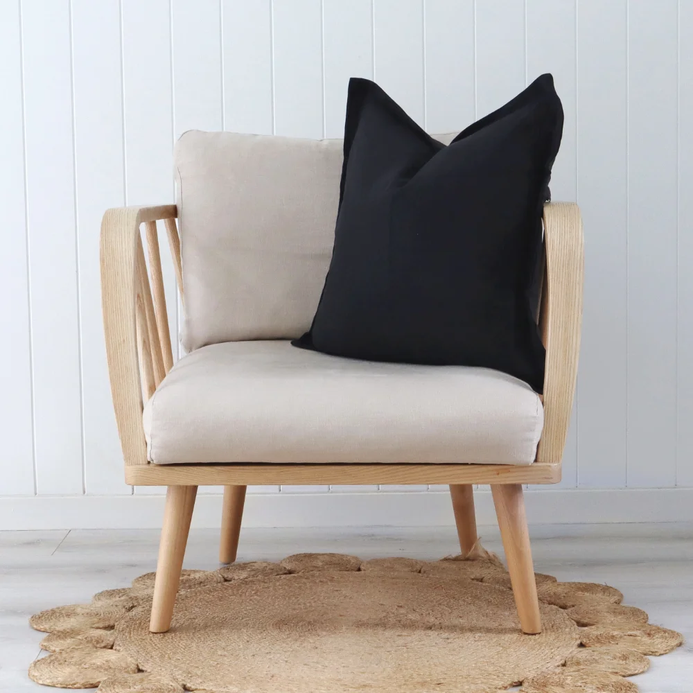 A single armchair shown featuring a black cushion.
