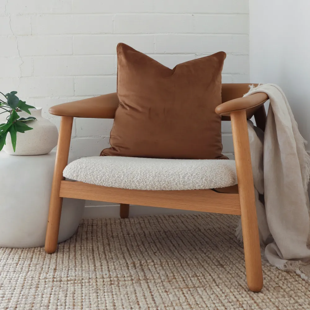 A single chair with a styled brown cushion arranged on it.