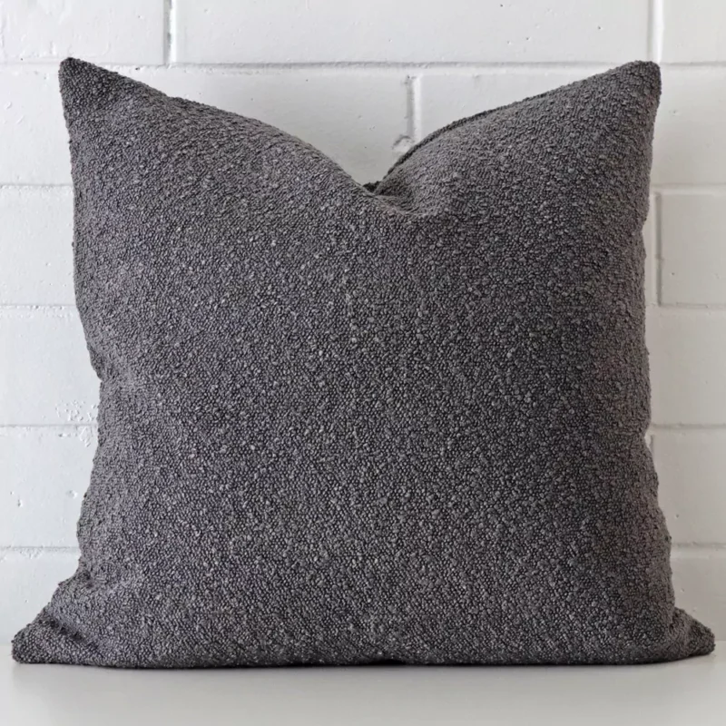 sofia-dark-grey-boucle-cushion-cover-large-sc1030-55 A lovely large dark grey cushion made from a boucle material cover arranged in front of a white wall.