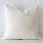 A hero shot of a boucle large cushion cover. It is made from a deluxe boucle fabric and features a white colour.