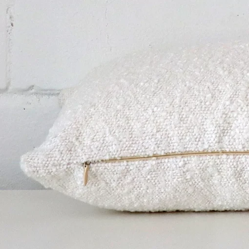 Side shot showing the seam of this rectangle white cushion that features a boucle material.
