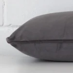 Lateral angle image of a velvet rectangle cushion. The space grey colour is highlighted.