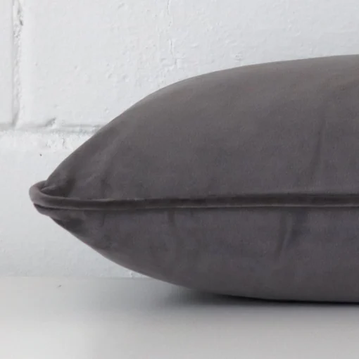 Lateral angle image of a velvet rectangle cushion. The space grey colour is highlighted.