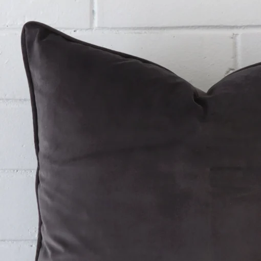 A magnified shot of a velvet cushion cover in a large size and a space grey colour.
