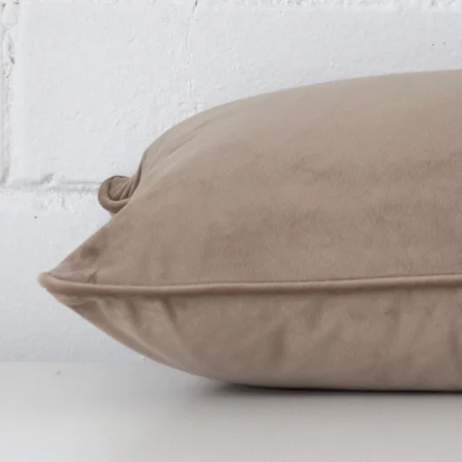 Enlarged image of the side of this taupe velvet cushion. The angle highlights the edge of its rectangle design