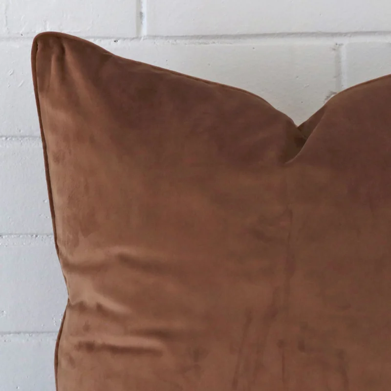 Close up of a velvet large cushion in brown.