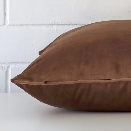 The seams of this velvet large cushion cover in brown are shown.