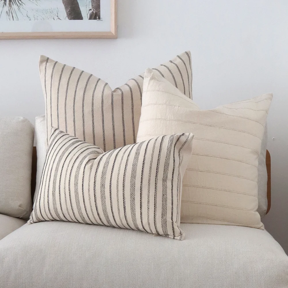 A three piece set of striped cushions in a light room.