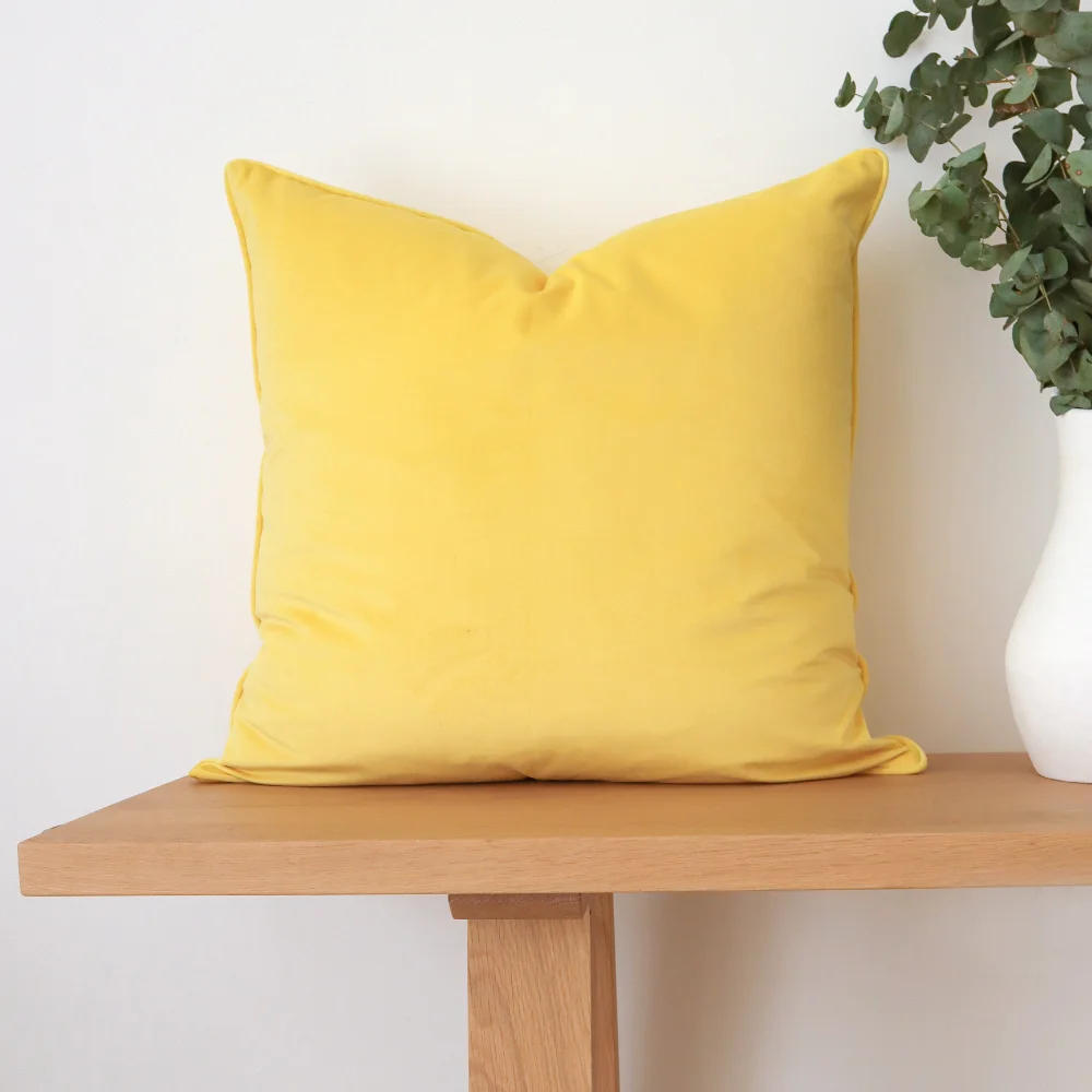 A timber seat with a yellow cushion sitting on top of it.
