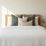 A white bed showcasing a set of 4 Vada designer cushion covers.