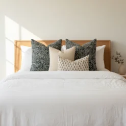 A white bed showcasing a set of 4 Vada designer cushion covers.