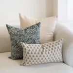 A set of 3 Vada designer covers are arranged on a natural-coloured sofa.
