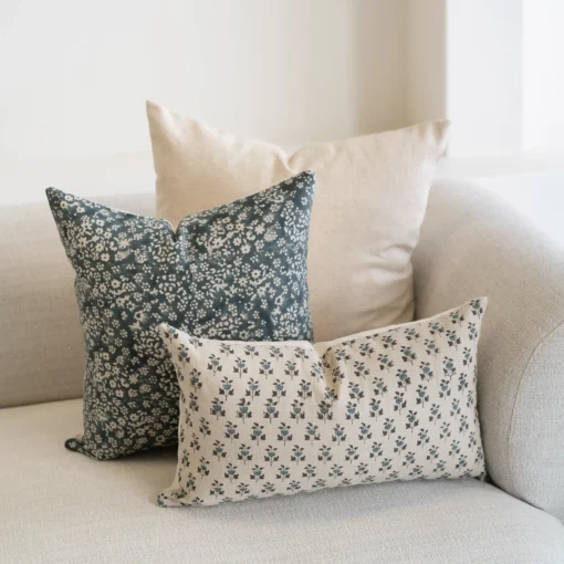 A set of 3 Vada designer covers are arranged on a natural-coloured sofa.