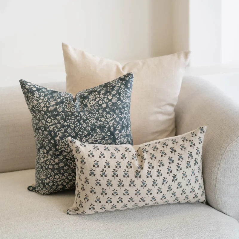 A set of 3 Vada designer covers are arranged on a natural-coloured sofa.