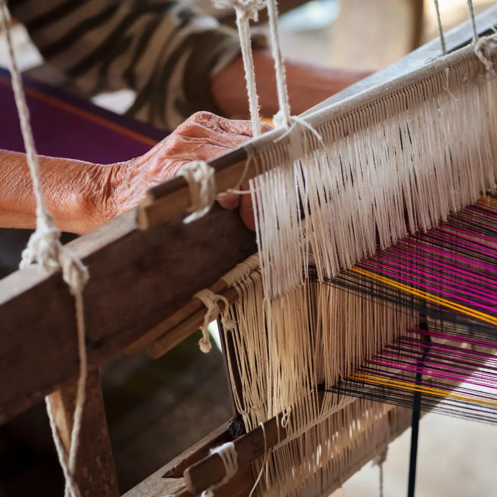 A vintage fabric loom is being used to make Thai textiles and material.