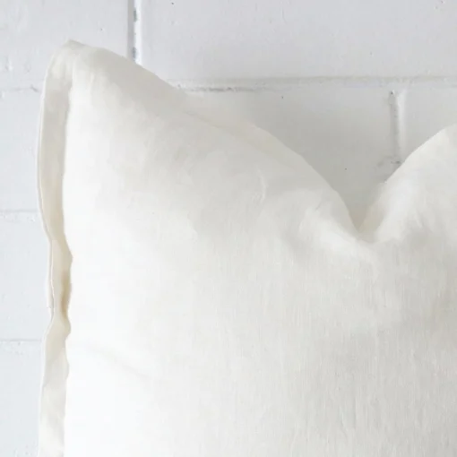 A zoomed view of this linen white cushion’s corner that shows a magnified view of its its large size.