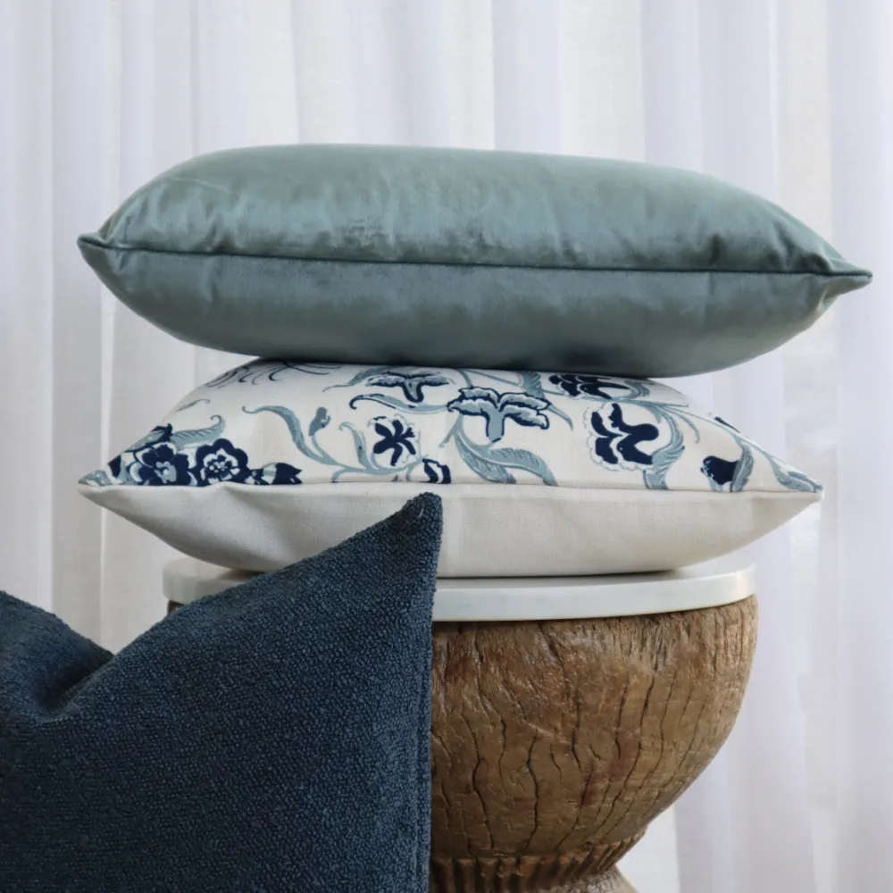 A wooden table is shown with a small stack of classic cushion sets on it.
