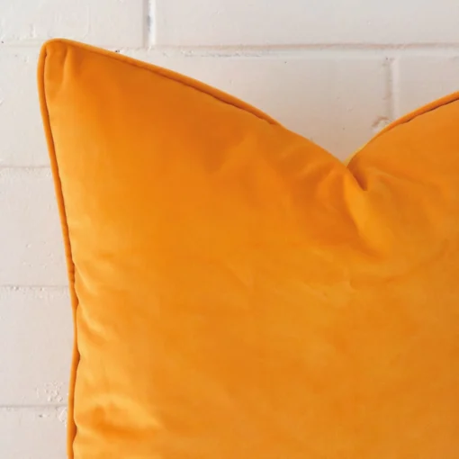 A close up image of this large cushion. The image shows details of its velvet fabric and yellow colour.